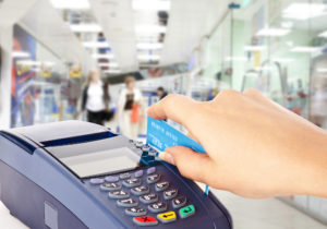 Human hand holding plastic card in payment machine