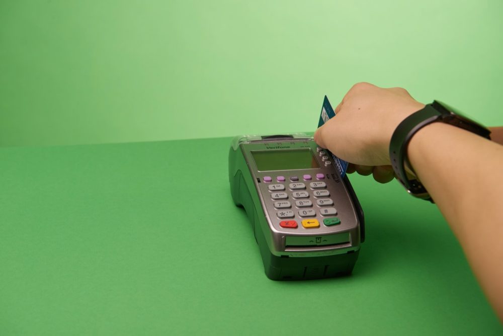 A hand swiping a credit card
