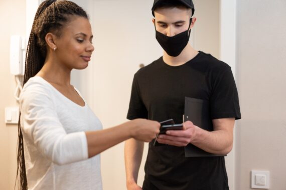 A man holding his phone next to a woman with a card