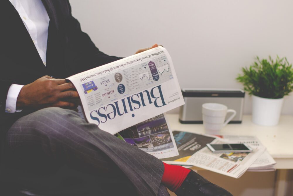 man with newspaper that says business