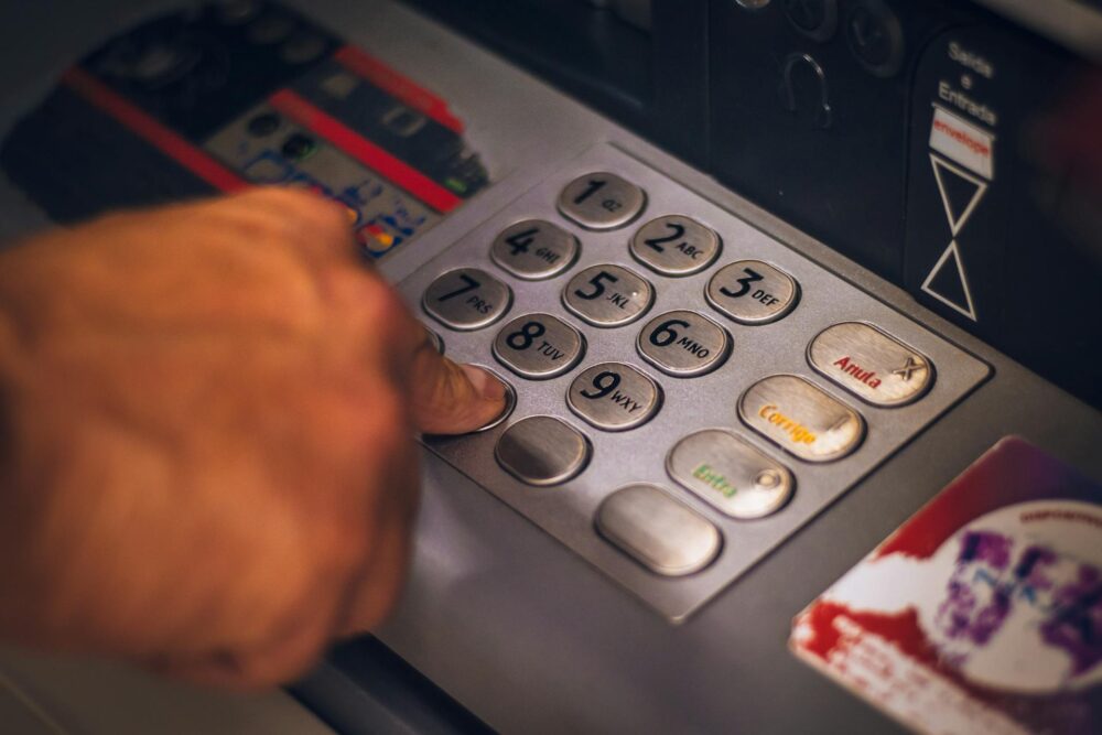 person pressing numbers on an ATM machine