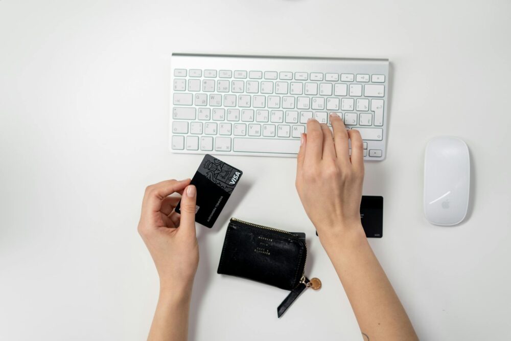 person using keyboard on mac and a card