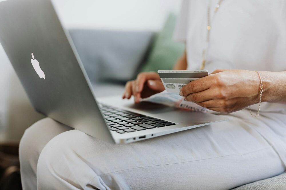 woman shopping on a laptop holding a card