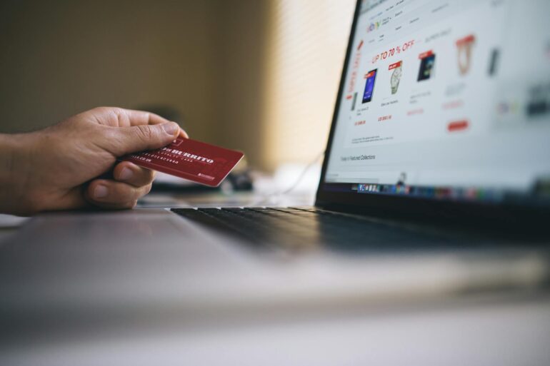 A man buying items with a card and a laptop