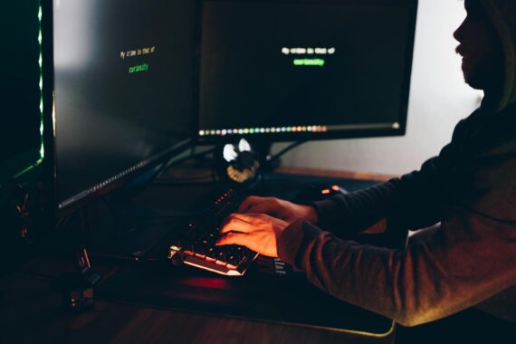 A man typing on a computer keyboard while hacking a system