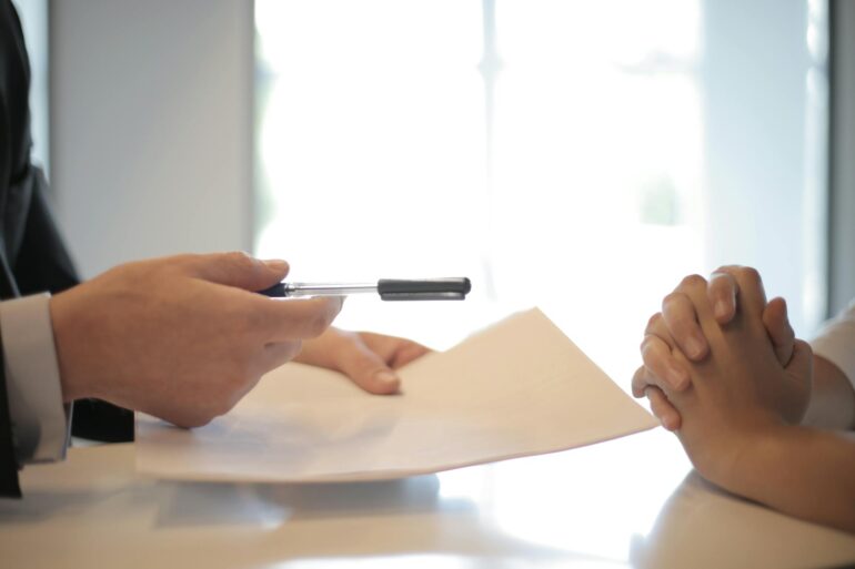 Businessman giving a contract to a woman to sign