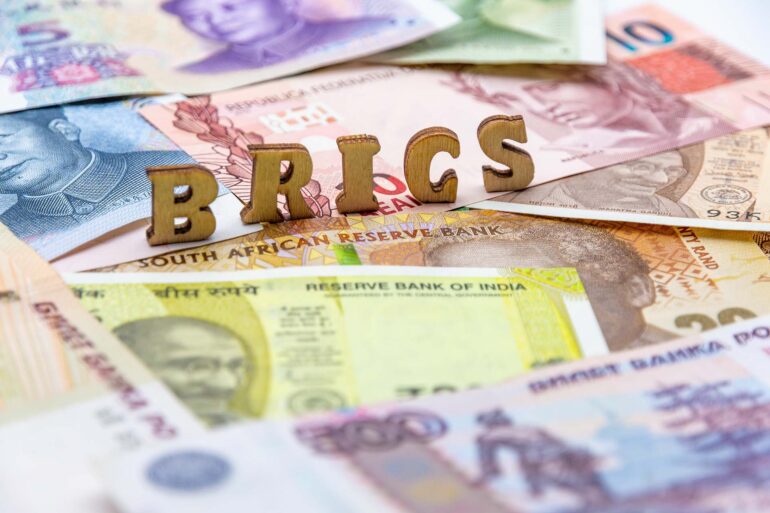 various currency banknotes with the letters BRICS on top